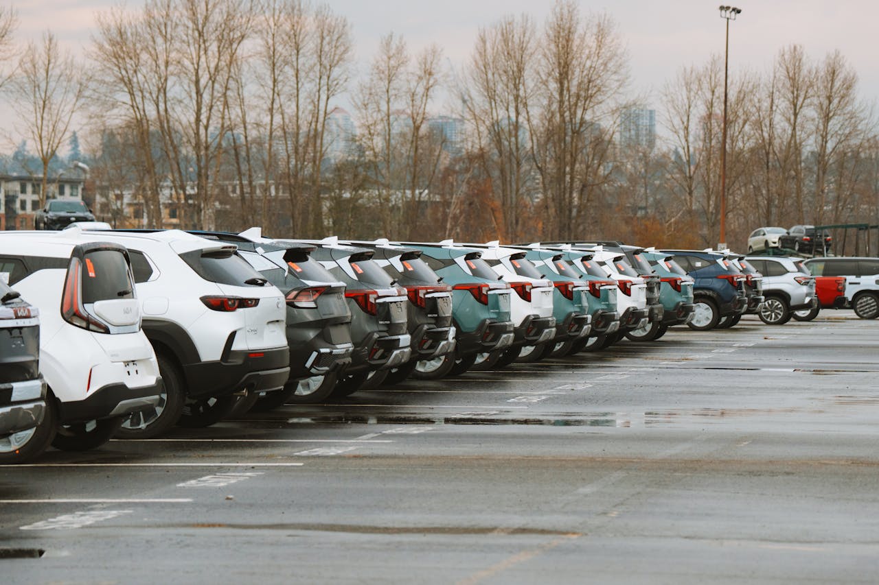 about-01 A line of parked cars in an outdoor urban parking lot on a cloudy day.